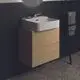 Waschtisch mit weißem Keramikbecken auf hellen Eichenholz-WTU-Schrank, ergänzt durch runden Spiegel und Wasserhahn, im modernen Badezimmerstil von Ideal Standard.